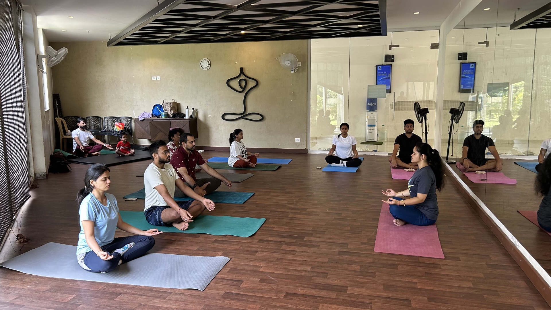 Group seated in meditation, forming a circle in the studio