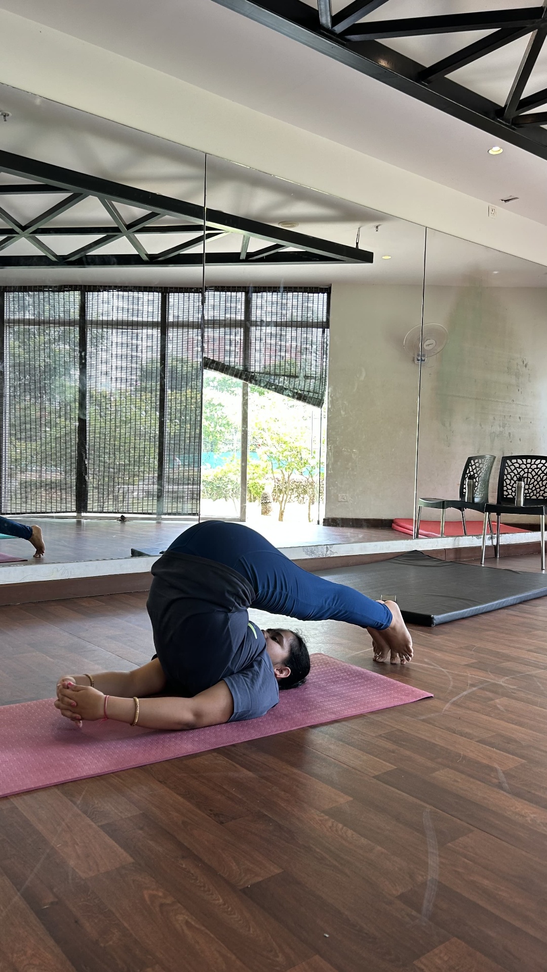 Priyamvada in Halasana (plough pose) on the mat